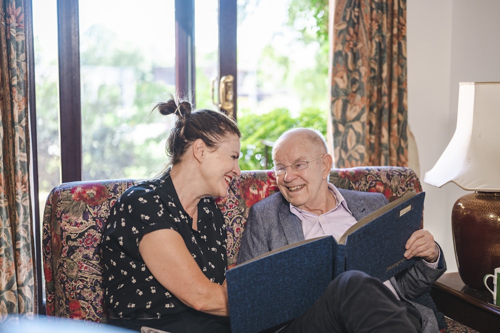 A caregiver and a man looking through a photo album together