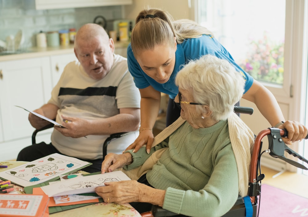A caregiver helping an elderly couple with an activity at home